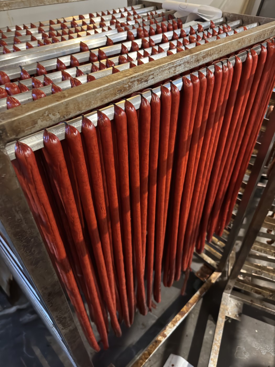 House-made meat sticks hanging on racks.